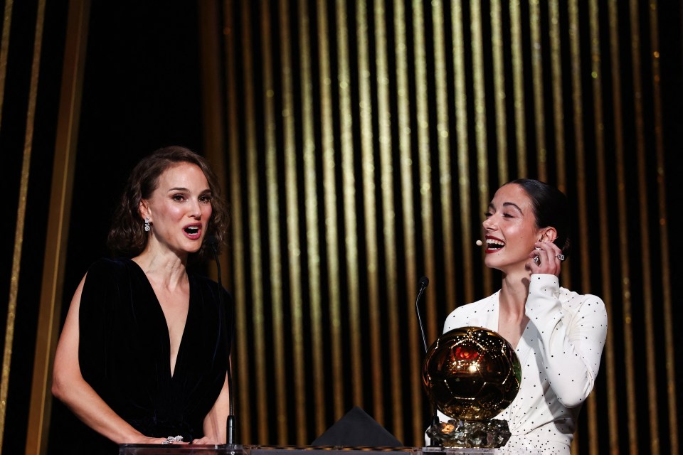 two women standing next to each other with one holding a trophy that says ' fifa ' on it