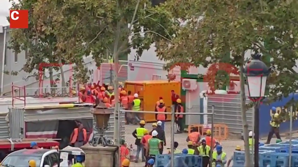 a group of construction workers are gathered in front of a building with the letter c above them