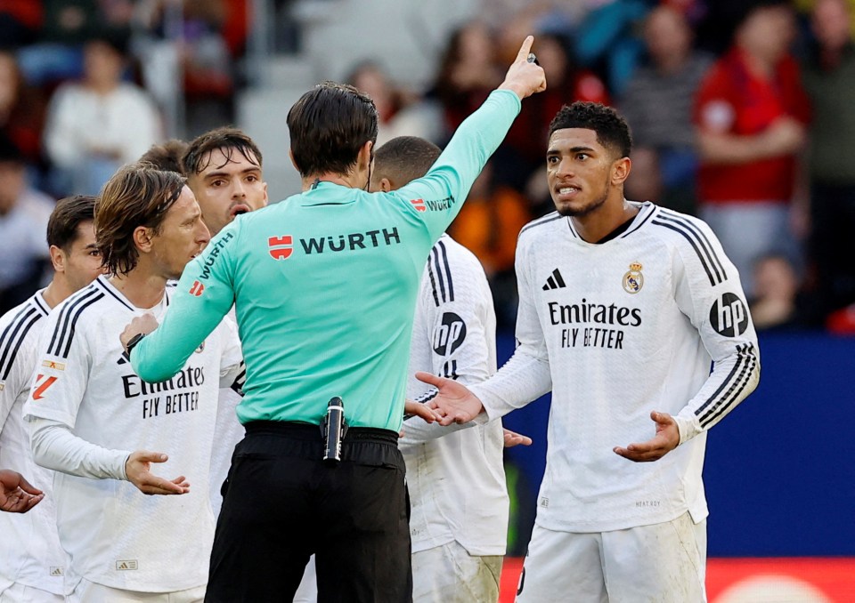 Jude Bellingham of Real Madrid receiving a red card from a referee.