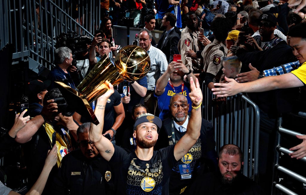 Stephen Curry (30) walks off the arena floor with the Larry O'Brien Trophy after the Golden State Warriors defeated the Cleveland Cavaliers in Game...