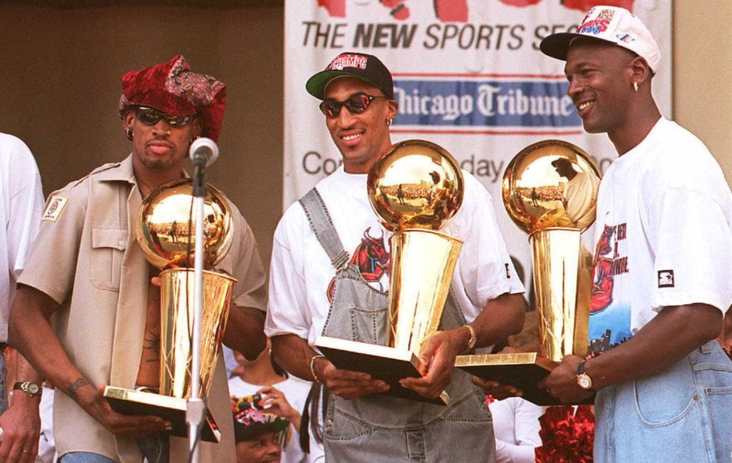 Chicago Bulls players Dennis Rodman (L), Scottie Pippen (C) and Michael Jordan (R) hold three of the team's four recent Larry O'Brien trophies 18 J...