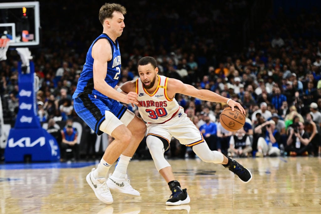 Stephen Curry #30 of the Golden State Warriors drives against Franz Wagner #22 of the Orlando Magic in the second half at Kia Center on February 27...