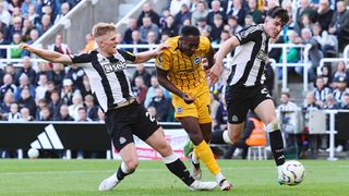 Danny Welbeck of Brighton & Hove Albion scores his team's first goal under pressure from Lewis Hall and Tino Livramento of Newcastle United during the Premier League match between Newcastle United FC and Brighton & Hove Albion FC at St James' Park on October 19, 2024 in Newcastle upon Tyne, England.