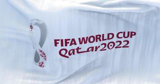 A white flag bearing the 2022 FIFA World Cup branding flaps in the wind in Doha, Qatar, October 2021