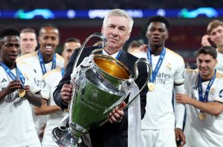 Carlo Ancelotti holds the Champions League trophy after Real Madrid's win over Borussia Dortmund at Wembley in June 2024.