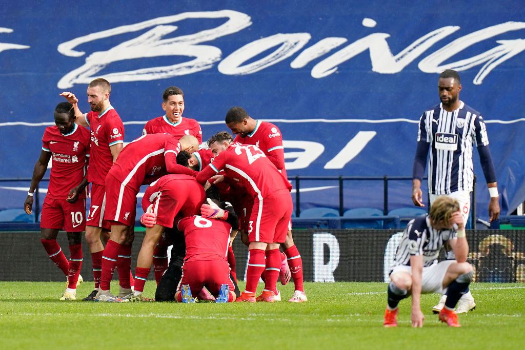Liverpool's Brazilian goalkeeper Alisson Becker celebrates scoring his team's second goal with teammates during the English Premier League football match between West Bromwich Albion and Liverpool at The Hawthorns stadium in West Bromwich, central England, on May 16, 2021. - - RESTRICTED TO EDITORIAL USE. No use with unauthorized audio, video, data, fixture lists, club/league logos or 'live' services. Online in-match use limited to 120 images. An additional 40 images may be used in extra time. No video emulation. Social media in-match use limited to 120 images. An additional 40 images may be used in extra time. No use in betting publications, games or single club/league/player publications. (Photo by Tim Keeton / POOL / AFP) / RESTRICTED TO EDITORIAL USE. No use with unauthorized audio, video, data, fixture lists, club/league logos or 'live' services. Online in-match use limited to 120 images. An additional 40 images may be used in extra time. No video emulation. Social media in-match use limited to 120 images. An additional 40 images may be used in extra time. No use in betting publications, games or single club/league/player publications. / RESTRICTED TO EDITORIAL USE. No use with unauthorized audio, video, data, fixture lists, club/league logos or 'live' services. Online in-match use limited to 120 images. An additional 40 images may be used in extra time. No video emulation. Social media in-match use limited to 120 images. An additional 40 images may be used in extra time. No use in betting publications, games or single club/league/player publications. (Photo by TIM KEETON/POOL/AFP via Getty Images)