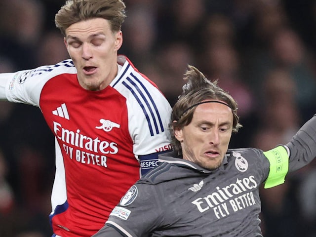 Martin Odegaard of Arsenal tackles Luka Modric of Real Madrid on April 8, 2025
