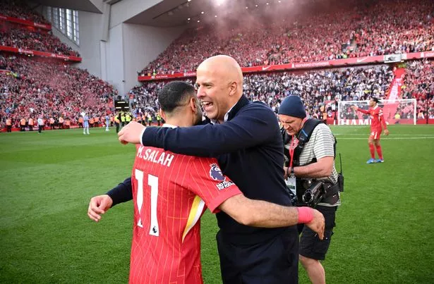 Arne Slot, Manger of Liverpool, embraces Mohamed Salah of Liverpool, as they celebrate the teams victory and confirmation of winning the Premier League title after the Premier League match between Liverpool FC and Tottenham Hotspur FC at Anfield on April 27, 2025 in Liverpool, England