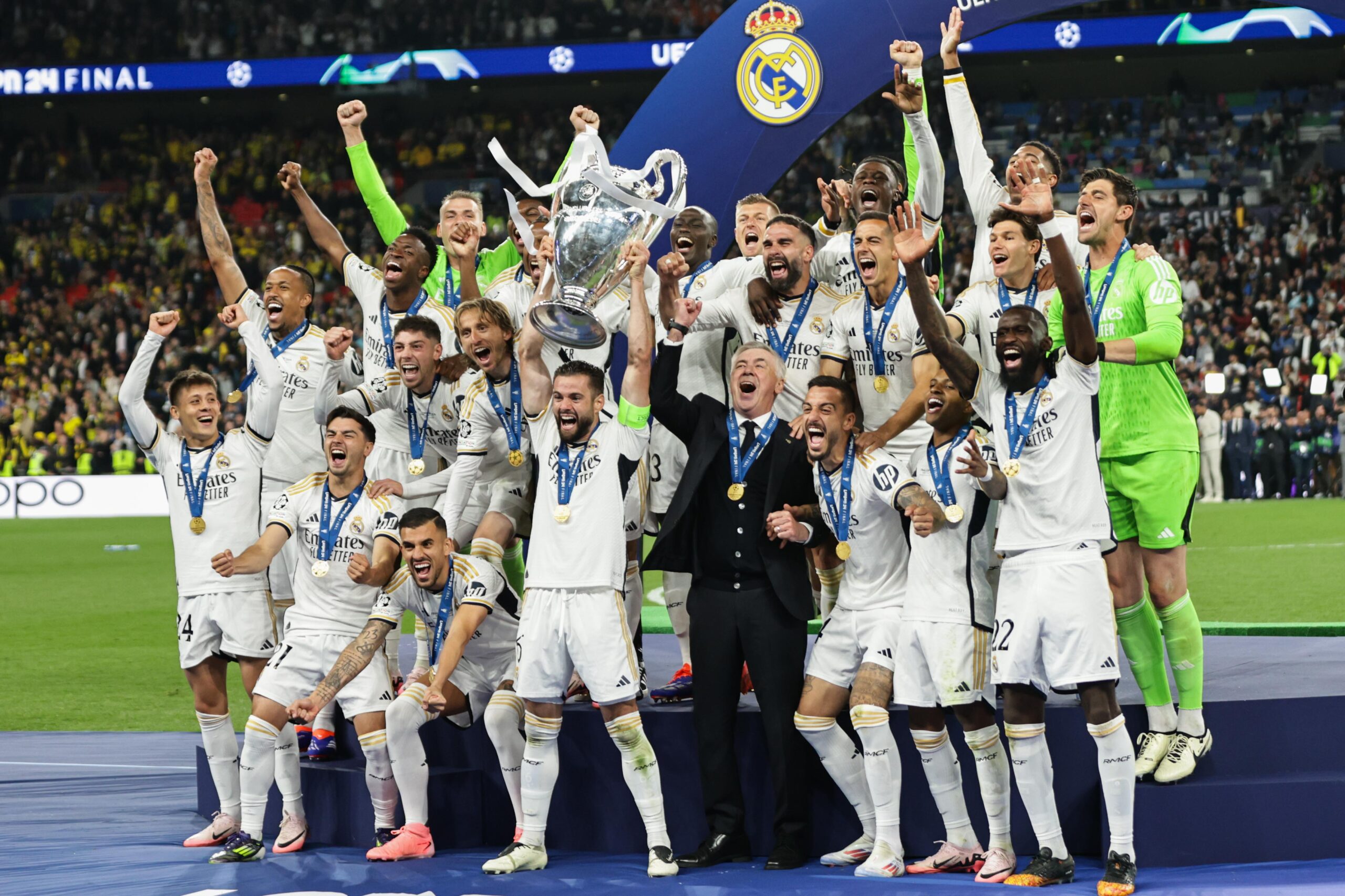 Real Madrid players and coach Carlo Ancelotti celebrate with the Champions League trophy after victory over Borussia Dortmund in the 2024 final at Wembley.