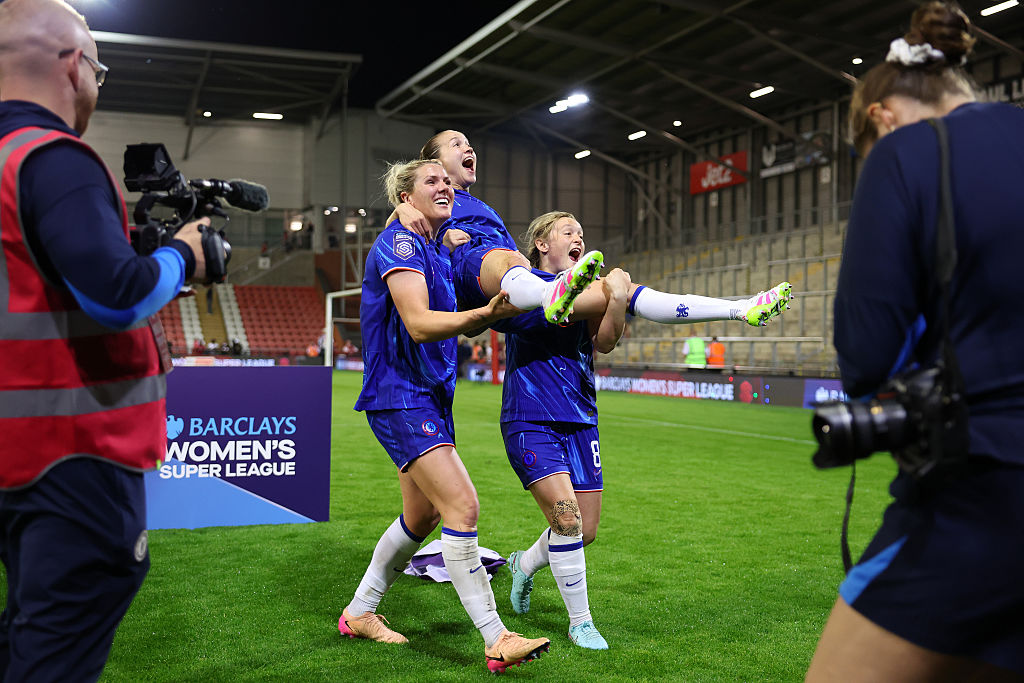 Millie Bright and Erin Cuthbert lift Guro Reiten in the air