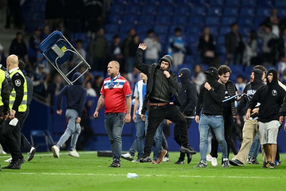 RCD Espanyol fans throwing a chair onto the pitch after a soccer match.