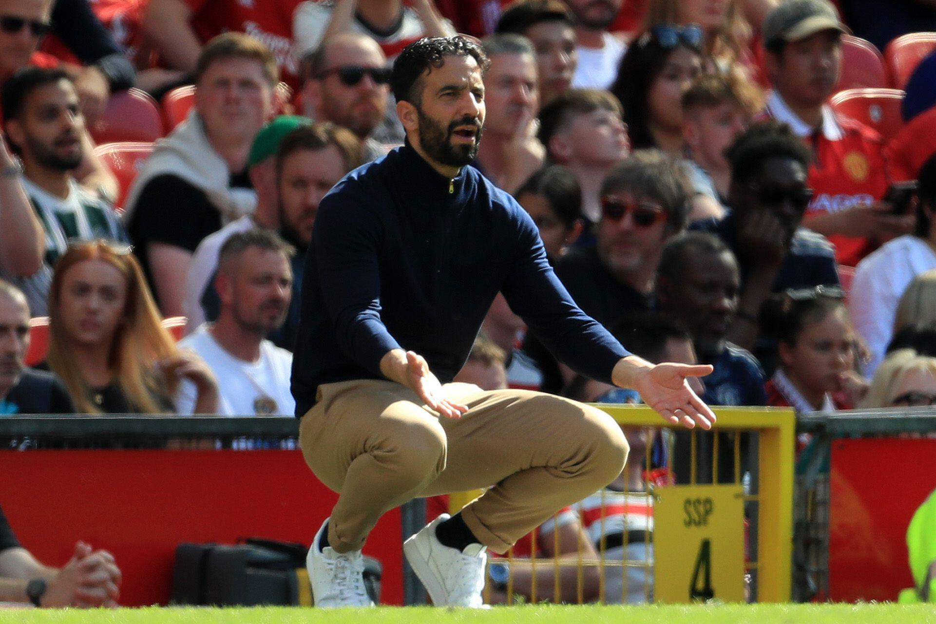 Manchester United head coach Ruben Amorim, crouching, reacts during the Premier League match against West Ham at Old Trafford, May 2025