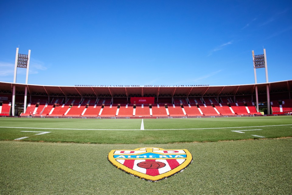 UD Almería's logo on the field of an empty soccer stadium.