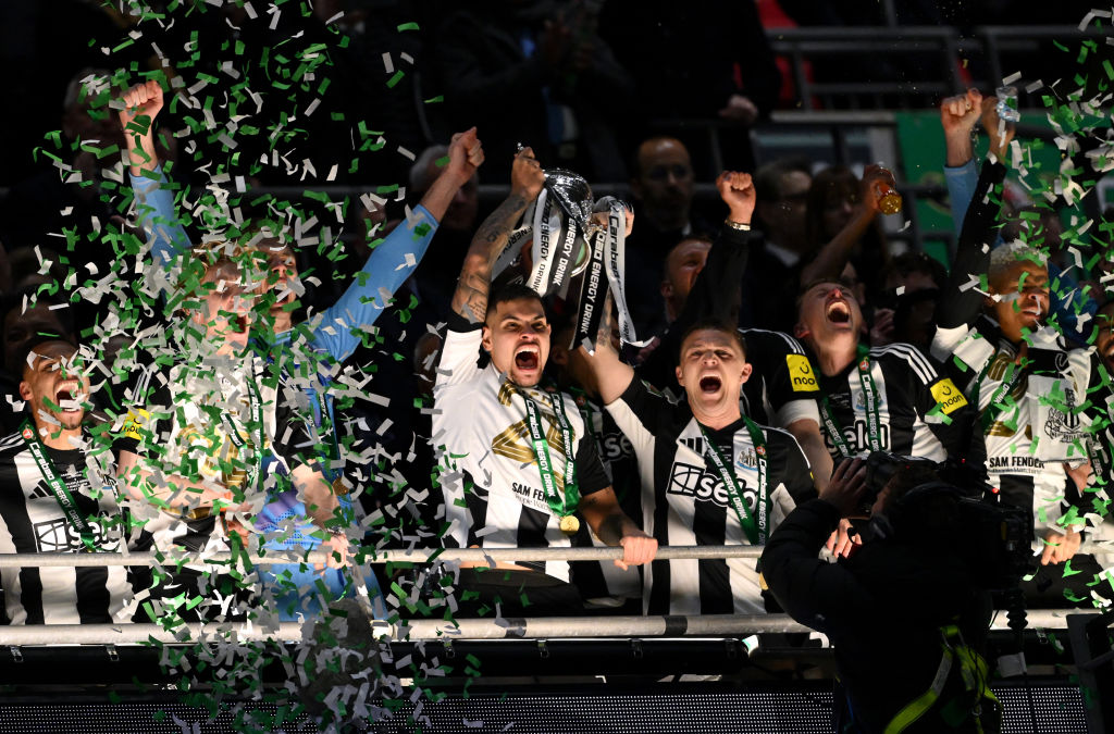 Bruno Guimaraes and Kieran Trippier of Newcastle United lift the Carabao Cup Trophy after their team's victory in the Carabao Cup Final between Liverpool and Newcastle United at Wembley Stadium on March 16, 2025 in London, England